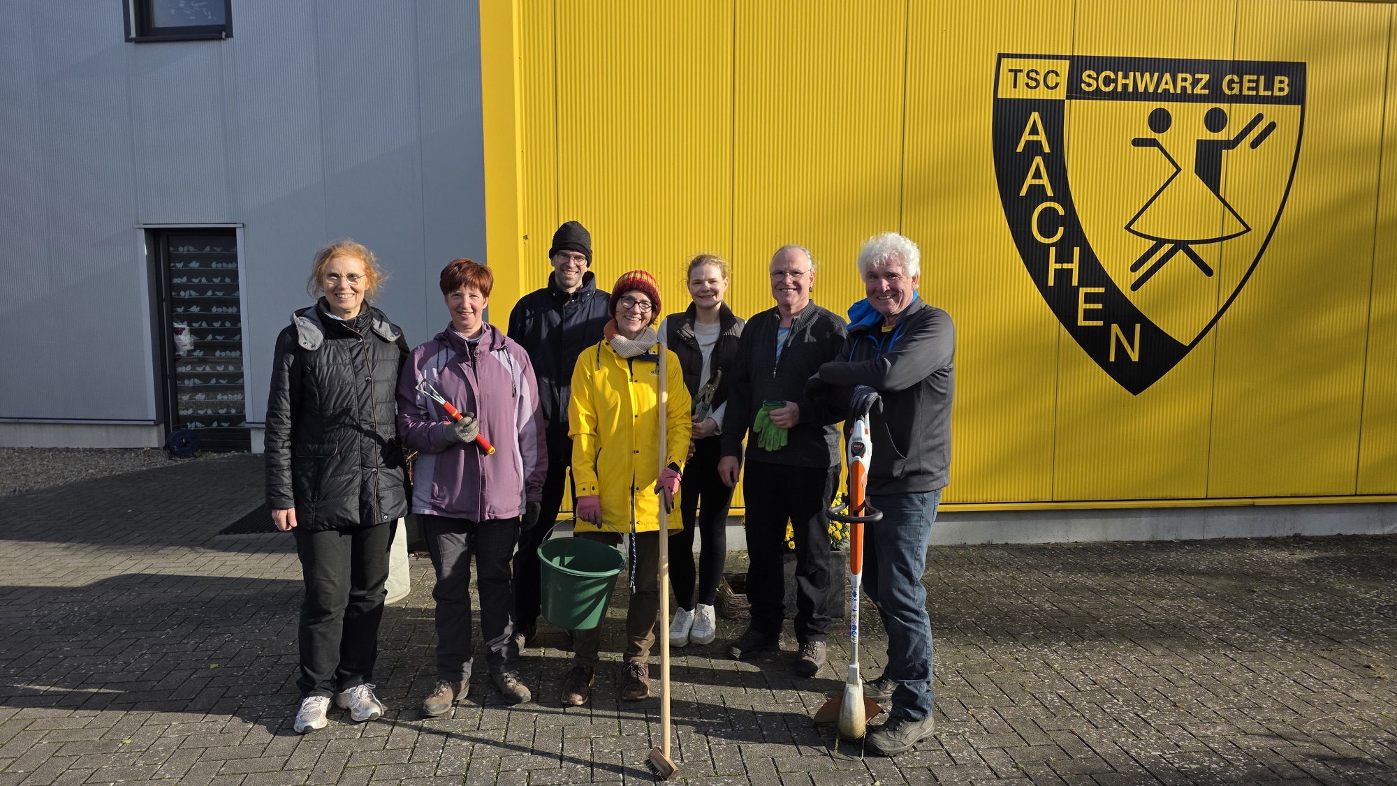 Engagierte Helferinnen und Helfer bei der Gartenarbeit vor dem Vereinsheim des TSC Schwarz-Gelb Aachen